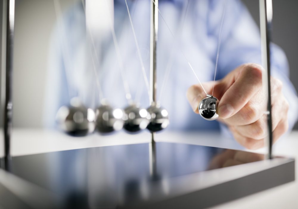 Gambar orang sedang memainkan Newton Cradle